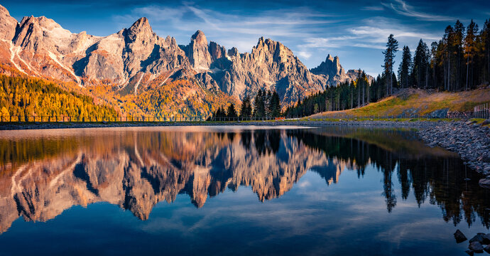 Pala di San Martino Mountain Range reflected in the surface of Malga Ces Lake. Spectacular autumn view of Dolomite Alps. Majestic outdoor scene of Italy, Europe. Beauty of nature concept background.