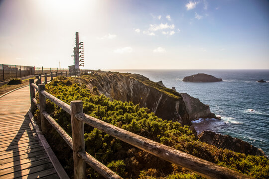 Wooden Boardwalk Along Cliffside with Signal Tower and Sea View. cabo Penas, Asturias, Spain