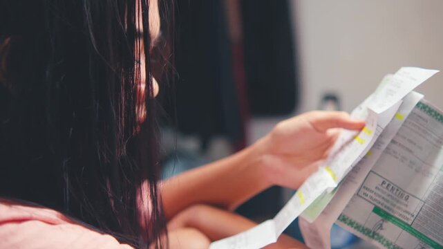 Woman Reading an Important Document or Bill (Over-the-Shoulder)