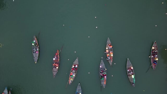 Aerial view of traditional wooden boats carrying people on the river in Hoi An, Da Nang, Vietnam.