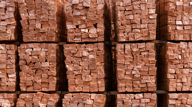 Industrial stack of heavy red clay bricks stored neatly in rows at a construction site warehouse ready for masonry and building development
