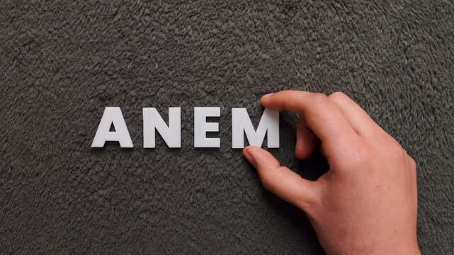 the word anemia written with white capital letters in a gray textured background (fast version)