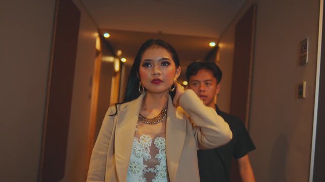 Glamorous Woman Removes Jacket Walking Down Hotel Hallway