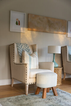 Beige wingback armchair draped with chevron throw and two pillows occupying cozy reading nook