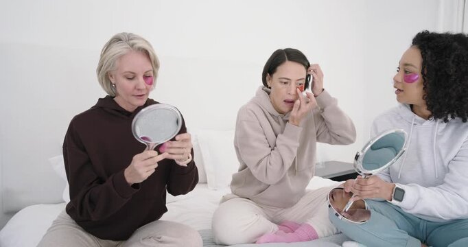 Diverse female friends on bed, center picking tube, assisting senior with gel patches and mirrors