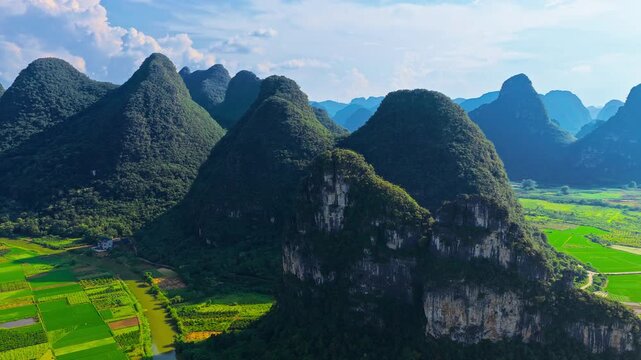Aerial panorama of lush karst mountains, river and rice fields in Guilin, China, showcasing iconic rural scenery and travel destination appeal.