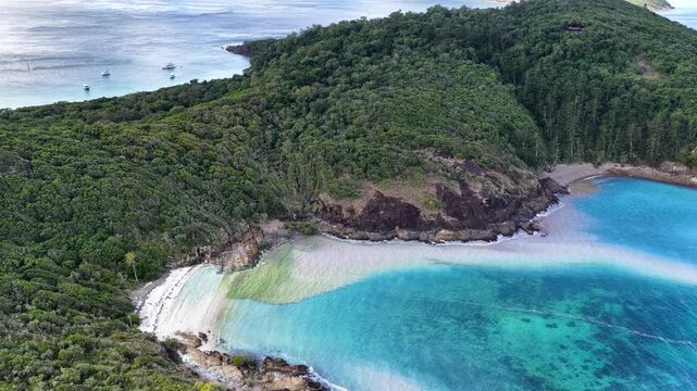 Aerial view of Mushroom Beach near Whitehaven Beach, with turquoise waters blurred by coral spawning and surrounded by a lush green coastline, Whitsunday Islands, Queensland, Australia.