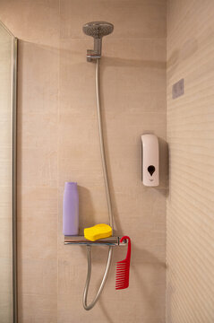A shower fixture with a purple shampoo bottle and yellow sponge.
