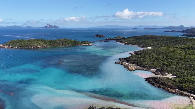 Aerial view of Mushroom Beach near Whitehaven Beach, surrounded by turquoise waters with coral spawning and lush green islands, Whitsunday Islands, Queensland, Australia.