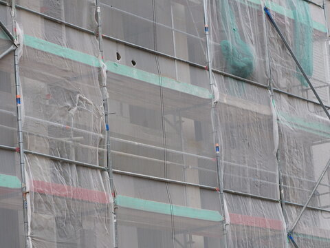 Facade scaffolding with safety nets and tarps on a building during construction or renovation work