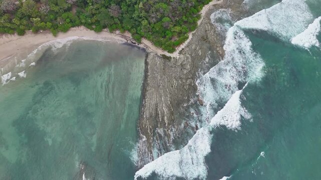 Aerial view of ocean waves crashing against rocks at Manzanillo Beach, Costa Rica