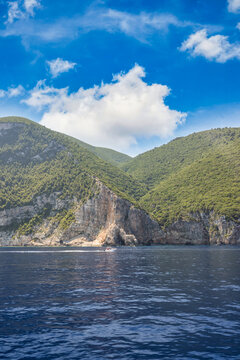 Breathtaking green limestone cliffs crystal clear blue sea rugged Greek coastline summer bay paradise view. Peaceful summer nature seascape landscape. Scenic Mediterranean travel tranquil wellbeing