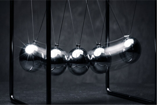 Newton's cradle balancing steel spheres illustrating momentum, physics principles, and cause and effect concepts
