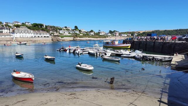 St Mawes Cornwall England UK. 13.08.2026. Video. St Mawes a popular Cornish resort at low low tide  and a passenger ferry alongside the harbour wall with waiting passengers.