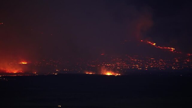 Panning view of a wildfire burning in the Utah desert at night near Simpson Springs.