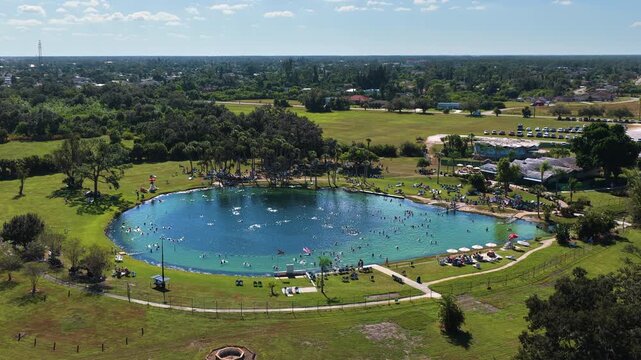 Aerial view of Warm Mineral Springs in North Port, Florida. Turquoise water, circular sinkhole and visitors swimming in natural geothermal lagoon surrounded by lush greenery