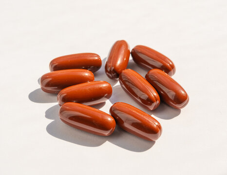 Brown gel pills, dark red capsules close up