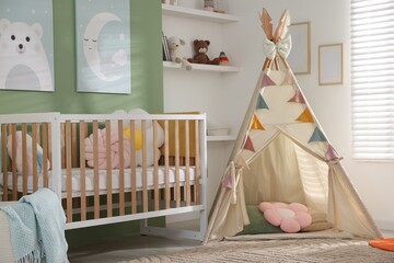 Cute baby room interior with comfortable crib, wigwam and other toys © New Africa