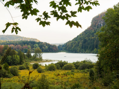 Vue panoramique sur le lac du Grand Maclu &agrave; La Chaux-du-Dombief dans le Jura, entour&eacute; de for&ecirc;ts et de falaises