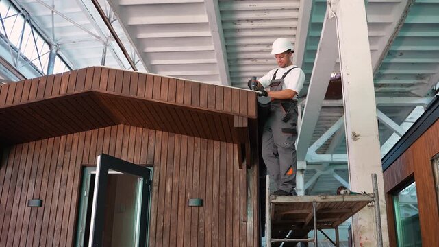 Professional builder installing gutter on a modular house roof