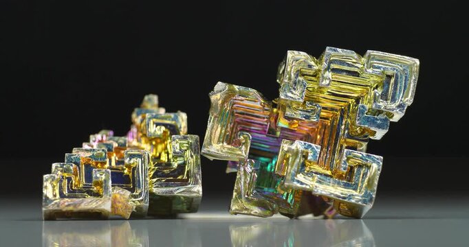 Colorful bismuth crystals with a distinctive stepped structure and iridescent oxide coating, highlighting the beauty of this unique metallic element