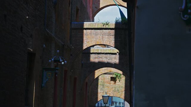 Historic brick archways architecture details in the narrow street alley of Siena, Tuscany, Italy