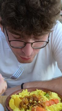 Marrakech, morocco. August 9, 2026. Caucasian man eating a traditional moroccan vegetable couscous tagine. Culinary tourism experience, enjoying local north african food