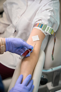Adult undergoing blood draw in medical facility