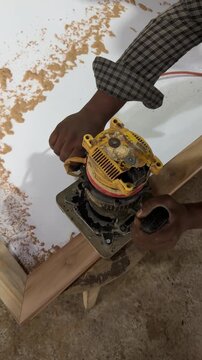 Carpenter Trimming Wood Frame Edge Electric Wood Router. Vertical video high angle close up of craftsman routing timber border in workshop. Ideal for woodworking ads.