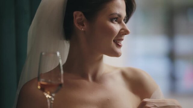 Elegant bride enjoying champagne wine in beautiful wedding attire and veil