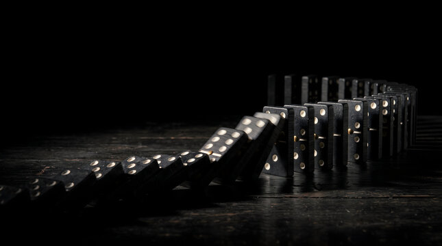 Domino chain reaction falling black tiles business strategy concept