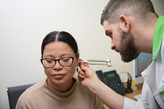 Woman undergoing audiology test with doctor in medical office
