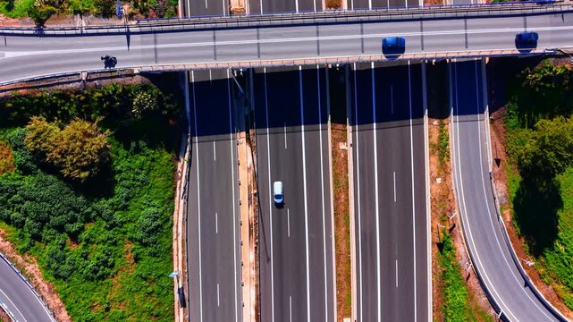 Overhead view of cars on a wide multi lane highway, Spain. Vehicles travel in separate directions with painted lane markings and central median.