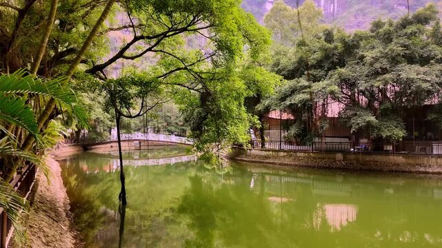 Tranquil River Bend with Lush Green Trees and White Stone Bridge at Trang An in Ninh Binh Vietnam - Stabilized Gimbal Shot Color Graded B-Roll