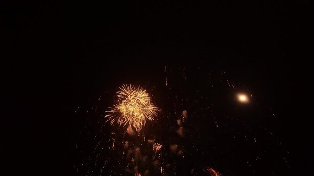 Golden Fireworks Exploding and Imploding in Reverse Motion Against Dark Night Sky: 4K Travel VFX Stock Video