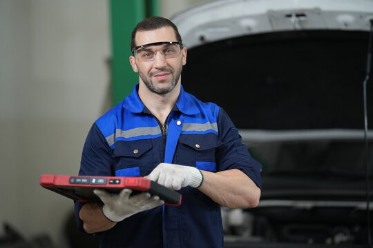 Professional Automotive Technician Using Diagnostic Scanner in Car Service Workshop