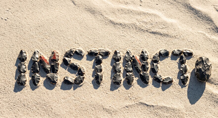 Fototapeta premium Seashell lettering spells insurance on sunlit beach sand