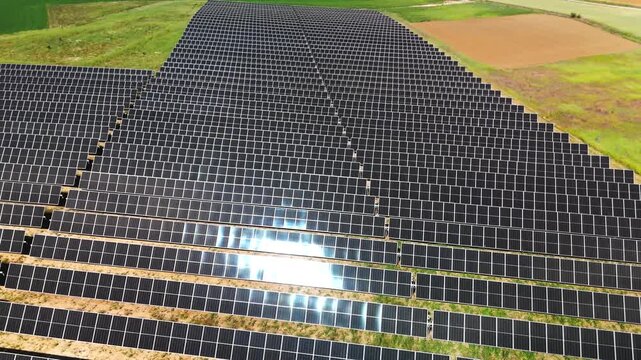 Drone push-in across reflective solar panel rows in Avila Spain