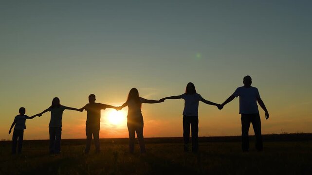 standing strong together under a warm summer sky, joined hands show support, boy strides confidently as the girl keeps pace beside a parent., open field harmony: linked hands at sunset, teamwork