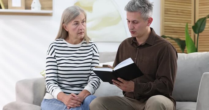 Pastor conducting Bible study with senior woman at home