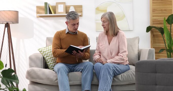 Pastor conducting Bible study with senior woman at home