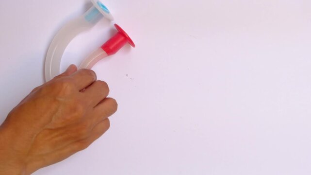 Set of colorful oropharyngeal airway tubes in different sizes arranged on white background, medical equipment for airway management