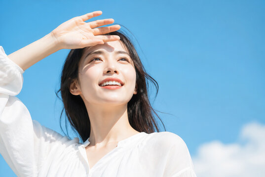 強い日差しを手で遮る笑顔の日本人女性 Generative AI