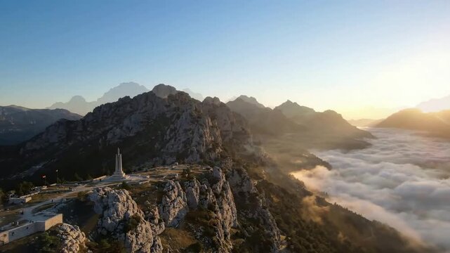 Aerial view of bulgarian flag waving at petrova niva monument above sea of clouds at sunrise memorial