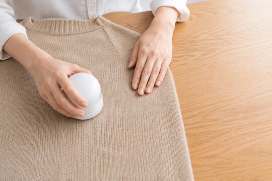 毛玉取り器でニットを手入れする日本人女性の手元