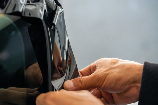 A car wrapping specialist applies a polyurethane film to the car. Detailer PPF