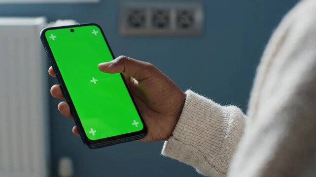 Person using smartphone with green screen for app mockup and ui tracking chroma key mobile app