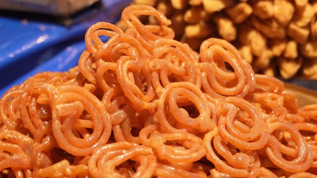 A close up cinematic view of popular indian sweet dish called jalebi, traditional delicious food in motion.