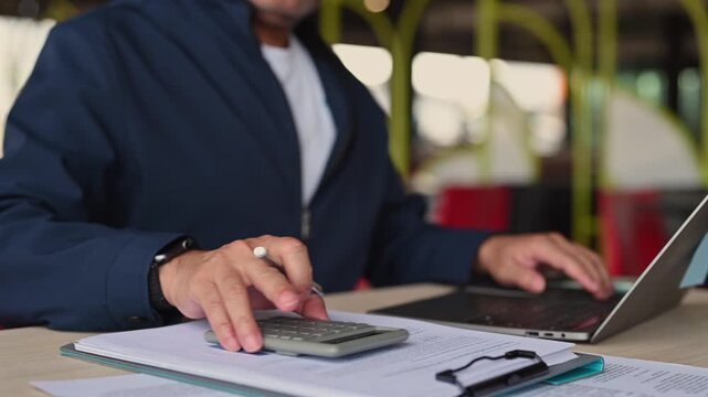 Business executive performing investment analysis, managing investment portfolio context inside office when investment planning requires accounting precision, overall accounting work near calculator.
