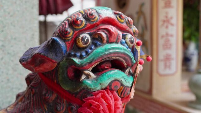 Vibrant Chinese guardian lion statue at the entrance of a temple